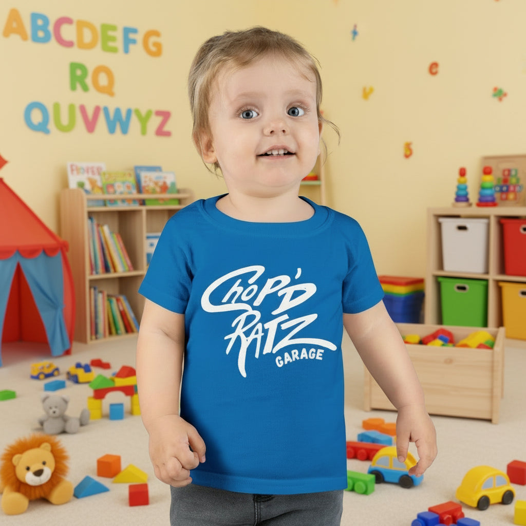Child wearing a blue teal t-shirt with 'Chop'd Ratz Garage' text 