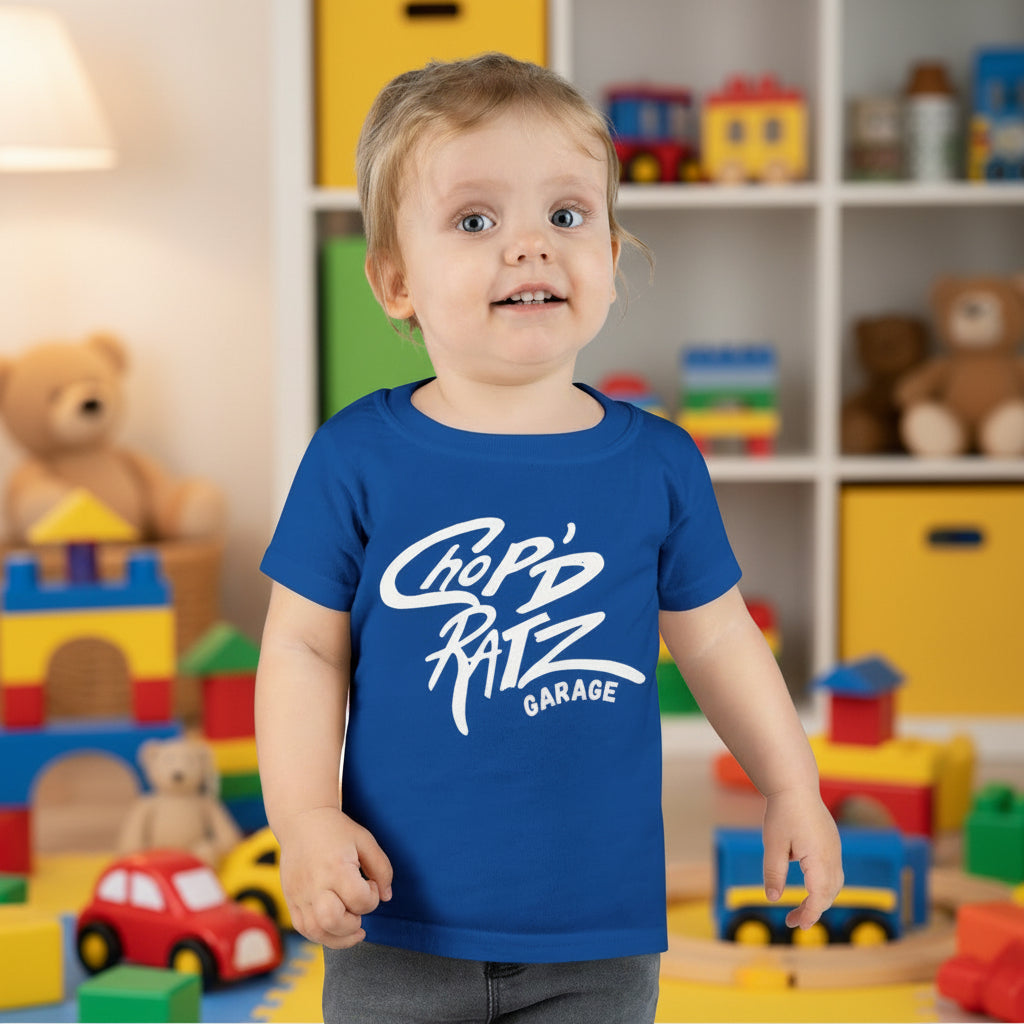 Child wearing a blue t-shirt with 'Chop'd Ratz Garage' text