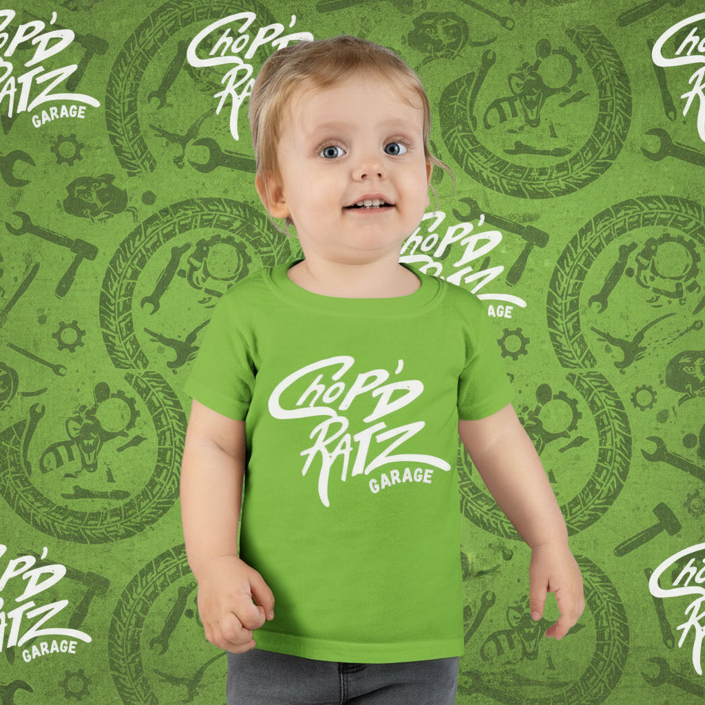 Child wearing a green t-shirt with 'Chop'd Ratz Garage' text 