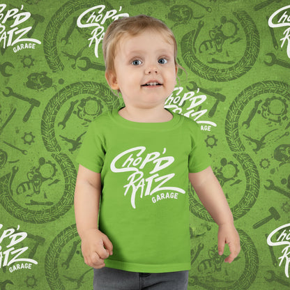 Child wearing a green t-shirt with 'Chop'd Ratz Garage' text 