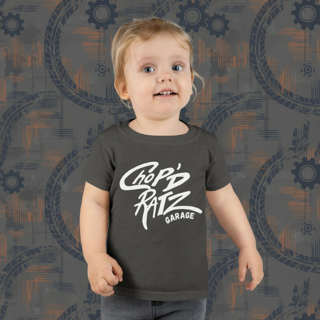 Child wearing a dark gray t-shirt with 'Chop'd Ratz Garage' text