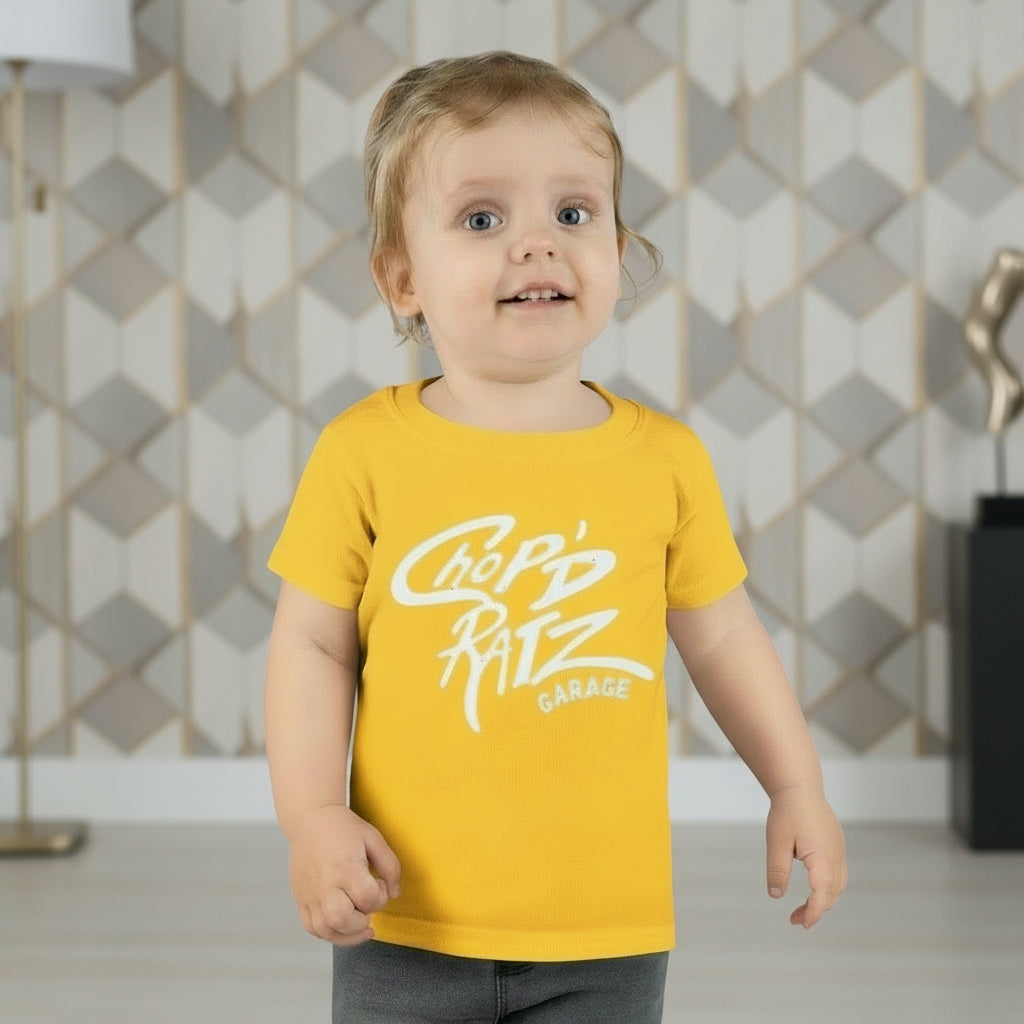 Child wearing a yellow t-shirt with 'Chop'd Ratz Garage' text 